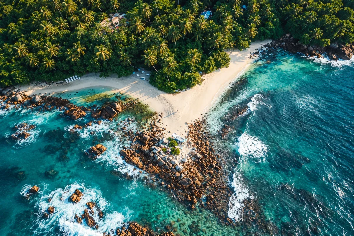 Aerial view of a sandy beach, coastal rocks and clear water in Mirissa