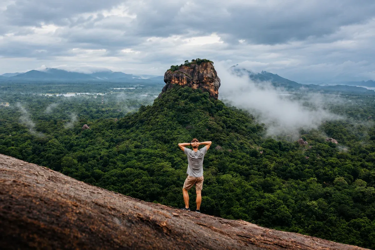 A visitor looking across the misty forest towards Sigiriya from Pidurangala