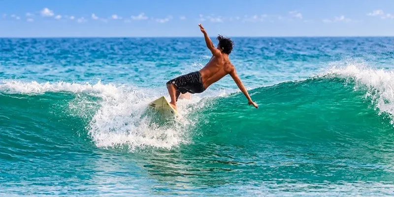 A surfer riding a turquoise ocean wave